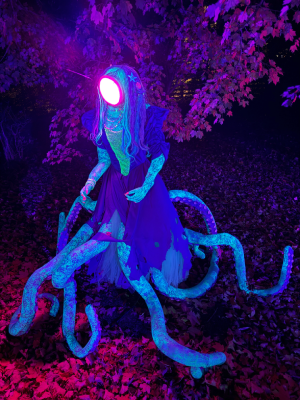 An octo mermaid with a lamprey face wearing a tattered 1980's prom dress.