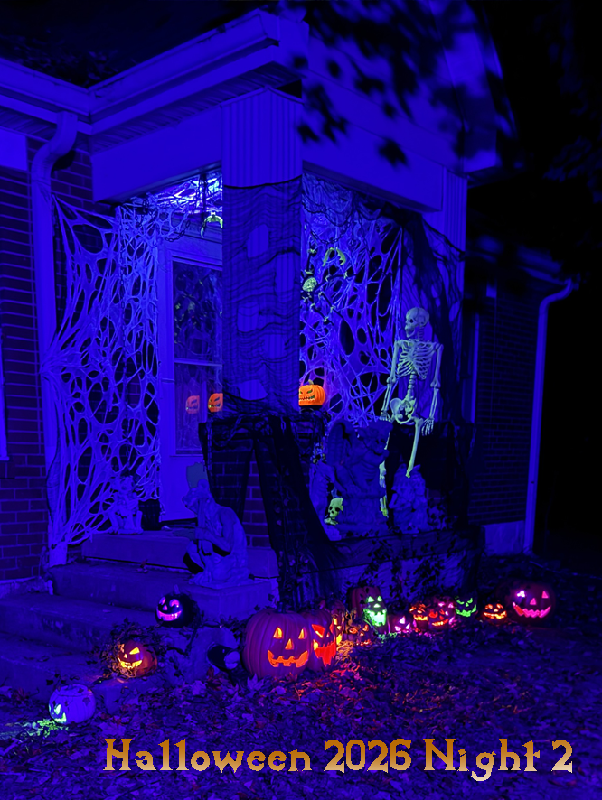 A porch covered in spiderwebs, a glowing skeleton, a glowing jack o lanters, and a large spider adorn the webs. A row of jack o lanterns lit in different colors. Text says Halloween 2026 Night 2